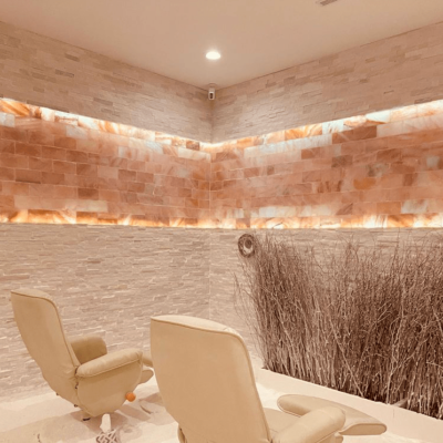 Two White Lounge Chairs Face A Stone Wall With A Line Of Himalayan Salt Bricks Crossing The Walls At The Salt Nest In Plantation, Florida