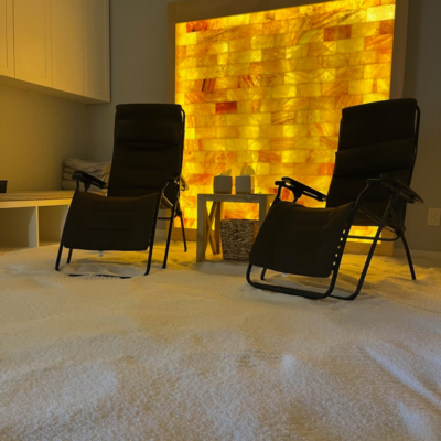A Salt Room With Two Chairs And A Himalayan Salt Brick Wall.