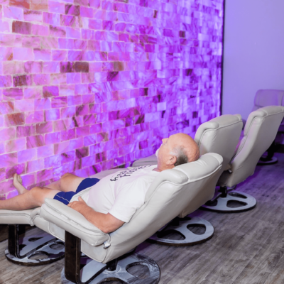 Man Laying In A Reclining Chair In A Salt Room With A Himalayan Salt Wall