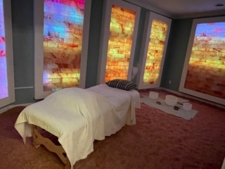 Willoway Spa &Amp; Wellness Center. Colorful Salt Room With A Massage Bed In The Middle. Salt Tiles Are A Mixture Of Pink, Blue, Yellow And White.