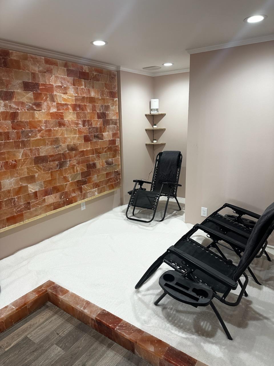 The Salt Therapy Room At Woodhaven Candle &Amp; Salt Therapy In Marion, South Carolina With Three Chairs And A Himalayan Salt Brick Wall.