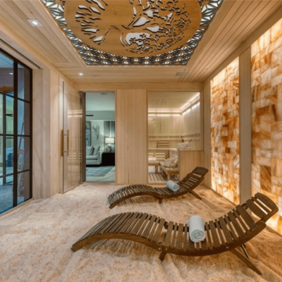 Two wooden chaises with towels on a salt-covered floor and backlit salt stone walls at a private residence in Newport Beach, California.