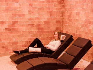 Pure Salt Studios. Three Lounge Chairs In Salt Room. On The Furthest Chair, Lays A Woman Relaxing And Smiling,
