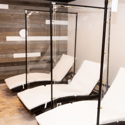 Three white chaises with three clear dividers at the SHarper the Medical Spa in Fishers, Indiana