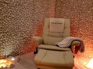 The Salt Room. Recliner In Corner Of Salt Room. Towels Lay On The Chair And A Cloth Is Draped Over The Back Of The Chair That Reads &Quot;The Salt Room.&Quot;