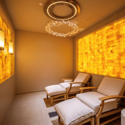 Two Cushioned Chaises With Two Orange Backlit Salt Walls With A Clear Salt Rock Chandelier At The Addison Reserve Country Club In Delray Beach, Florida.