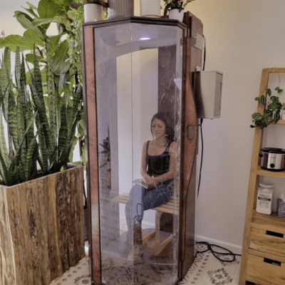 A woman in an Original SALT Booth for salt therapy at Bay Area Brain Spa in Albany, California.