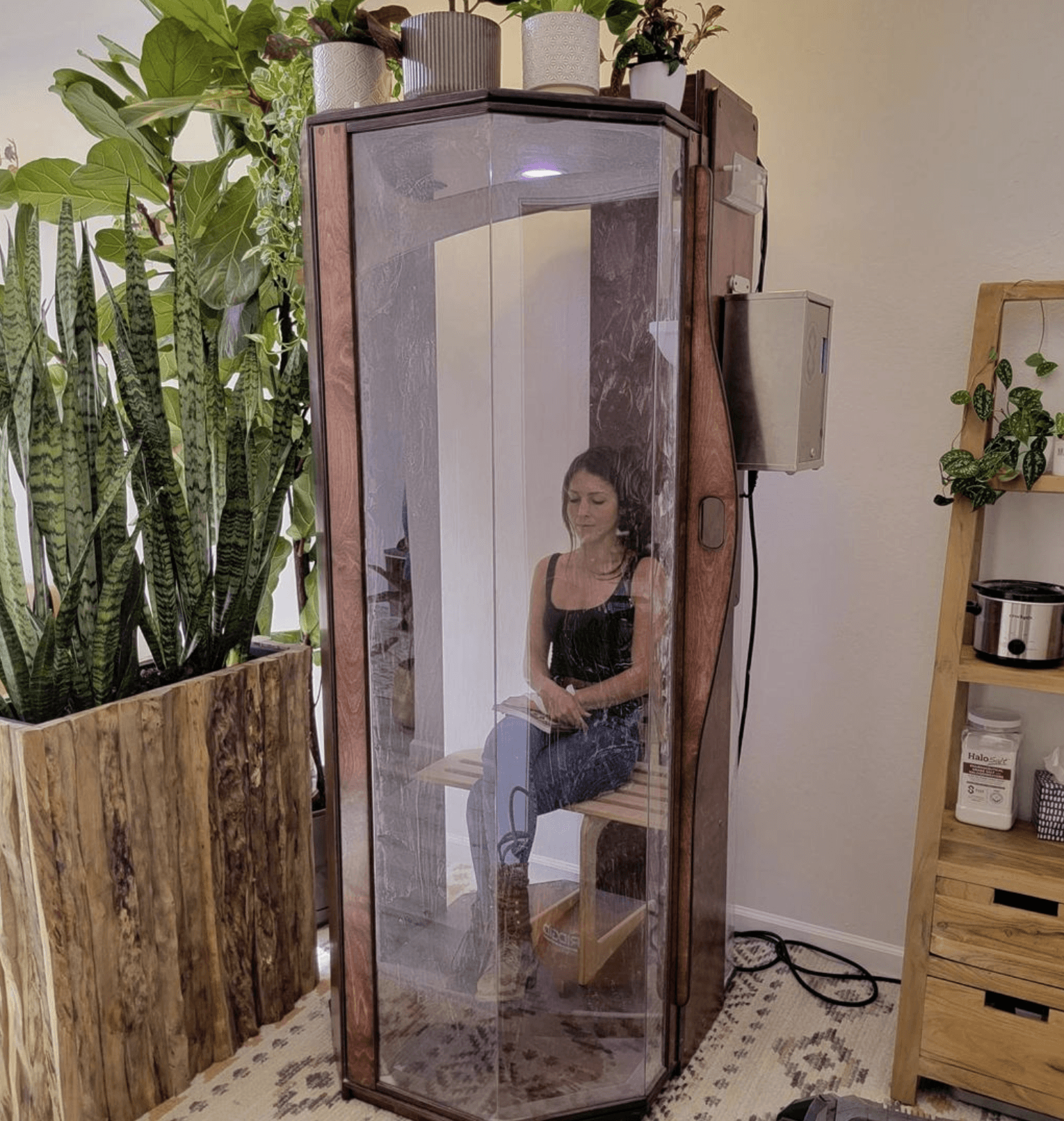 A woman in an Original SALT Booth for salt therapy at Bay Area Brain Spa in Albany, California.