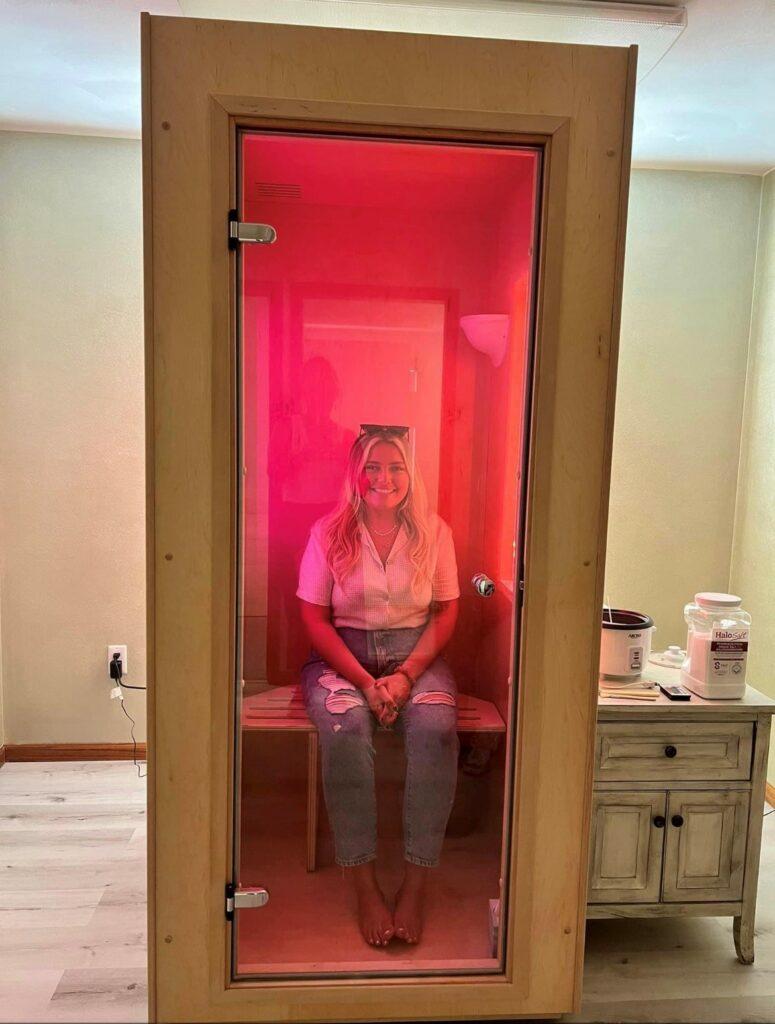 A woman in a SALT Booth FleX for a salt therapy session.