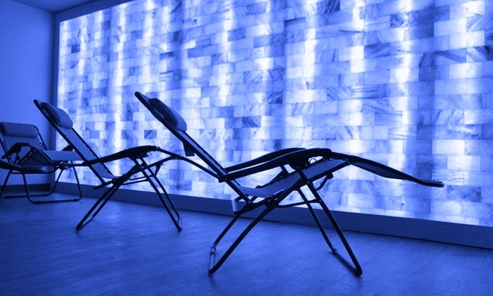 Lounge chairs in front of a salt brick wall backlit by LED light at Boca Cryo in Boca Raton, Florida