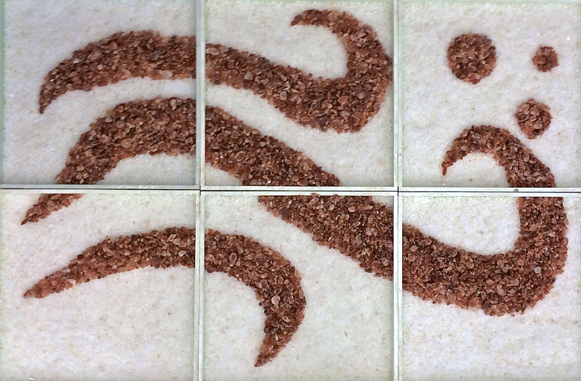 Three Different Sized Waves Of A Reddish Salt With Three Circles In The Top Right Hand Corner On A Bed Of White Salt.