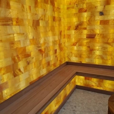 Wooden Booth With An Orange Backlit Salt Stone Paneled Wall At The Bungalows In Key Largo, Florida.