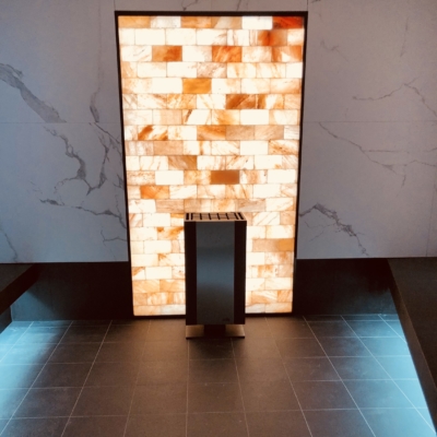 An Orange Back Lit Himalayan Salt Stone Panel On A Granite Wall And A Grey Squared Tile Floor On The Celebrityedge.