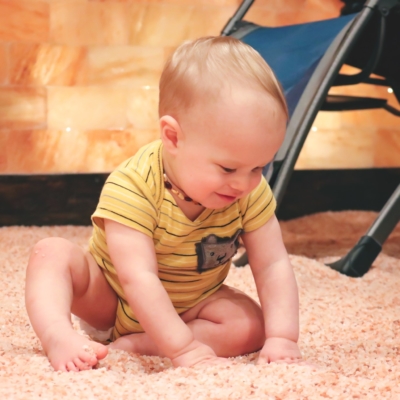 Young baby sitting on a Himalayan salt covered floor.
