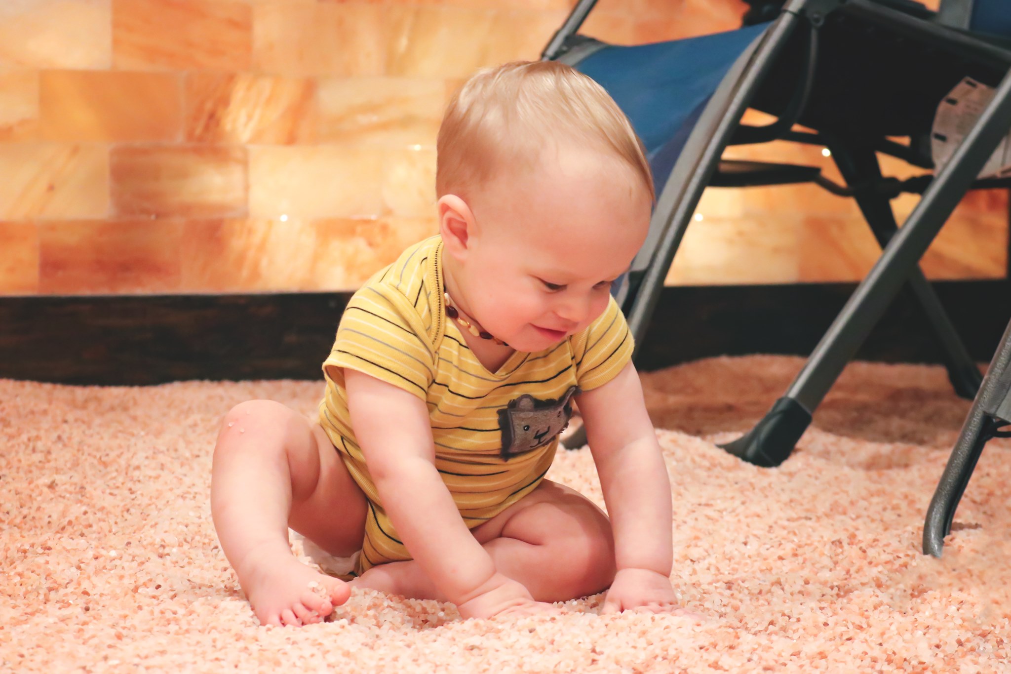 Young Baby Sitting On A Himalayan Salt Covered Floor.