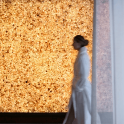 Woman In A White Robe Walking Around A Backlit Himalayan Salt Stone Wall At The Four Seasons Hotel In Austin Texas.