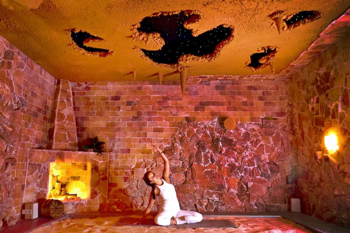 Woman In A Salt Cave Doing Yoga On A Mat On A Salt-Covered Floor At Healing Salt Cave &Amp; Wellness Spa - Guilford, Connecticut.