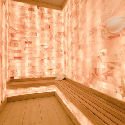 LED backlit Himalayan salt panel wall with a light brown bench and three towels stacked up in the corner at the Henderson Beach Resort - Destin, Florida.
