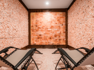 Two Reclined Chairs On A Salt Covered Floor Surrounded By Salt Stone Walls And A Paneled Himalayan Salt Stone Wall.