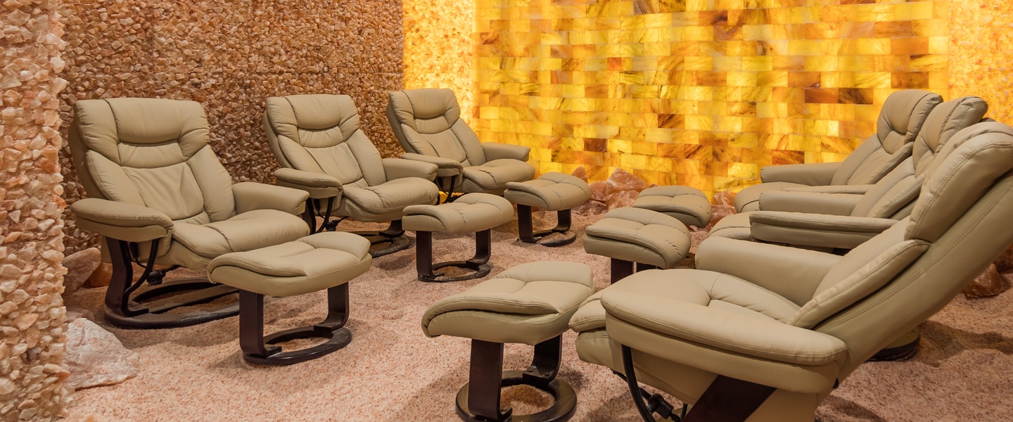 Six cushioned lounge chairs on a salt-covered floor surrounded by Himalayan salt brick walls and a LED backlit salt panel wall at the Kalahari - Pocono Manor, Pennsylvania.