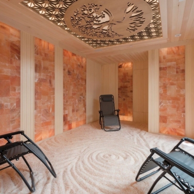 Three Grey Reclining Chairs On A White Salt-Covered Floor With Himalayan Salt Stone Walls And A Growing Tree Center Piece On The Ceiling.