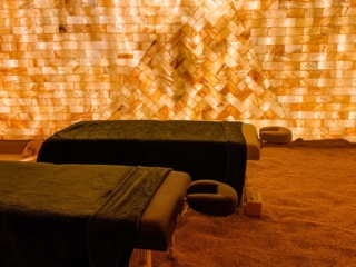 Two Massage Tables On A Salt-Covered Floor In Front Of A Led Backlit Salt Panel At The Prana Salt Cave  - Wilmington, North Carolina.