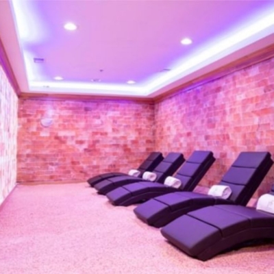 Five Black Chaises With Wrapped Blankets On A Salt-Covered Floor Surrounded By Himalayan Salt Stone Walls.