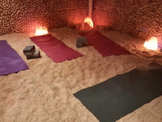 Four Yoga Mats On A Salt-Covered Floor With Lighted Himalayan Salt Stone Surrounded By Salt Brick Walls.