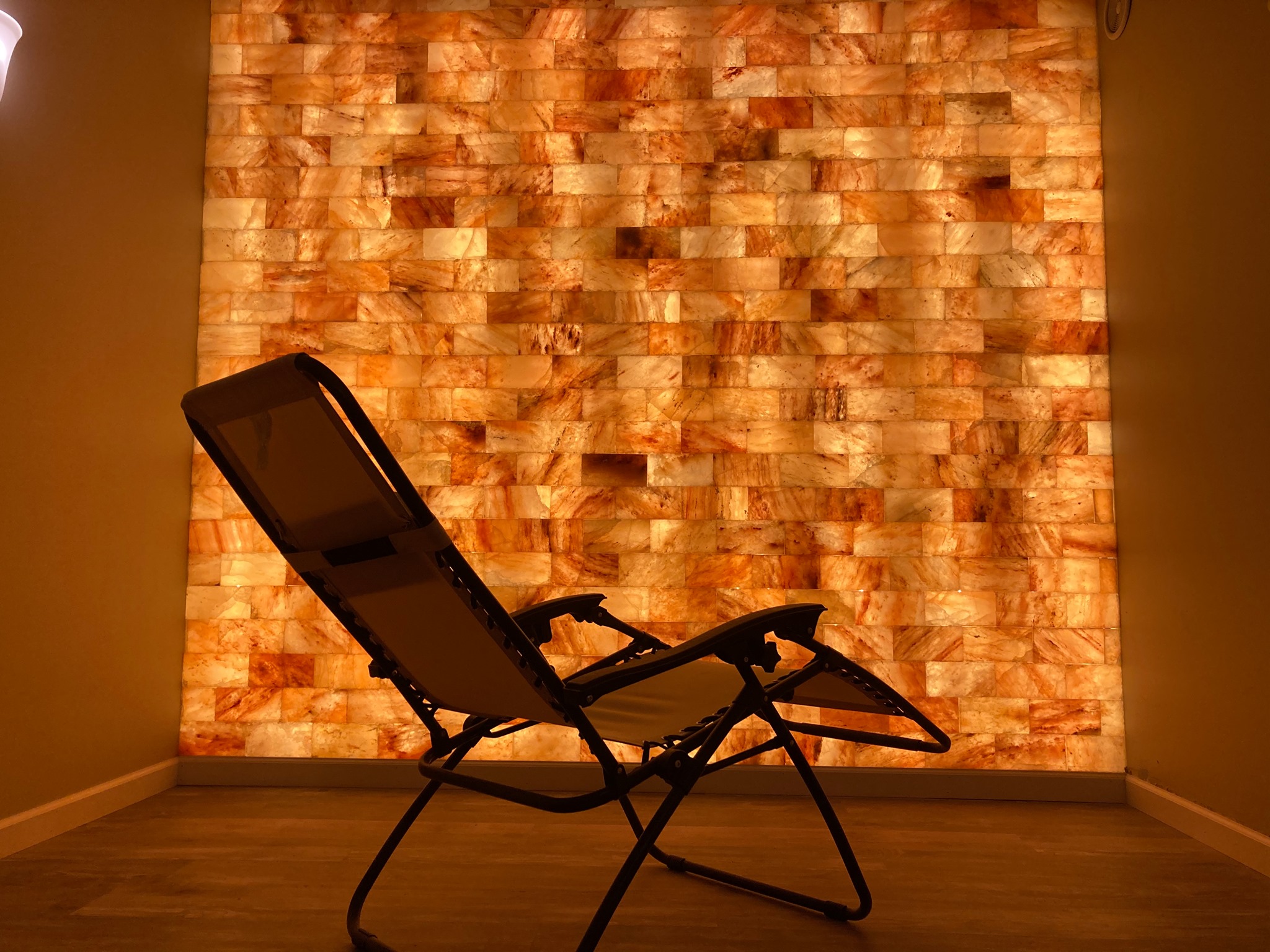 A Reclining Chair Facing A Led Backlit Salt Panel Wall At Restoring Eden - Gilsum, New Hampshire.