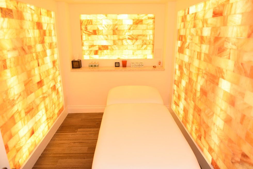 A White Massage Table Surrounded By Led Backlit Salt Panels At The Juhi Center - New York City, New York.