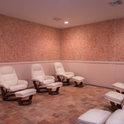 Seven White Chairs All With White Foot Rests On A Himalayan Salt Stone Floor And Walls At The Salt Box Parkland, Florida