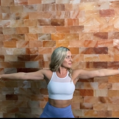 Woman Doing Yoga In Front Of A Himalayan Salt Panel Wall At The Salt Center - Alpharetta, Georgia.