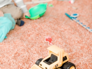 Young boy playing on a salt-covered floor and toy truck at The Salt House of Worthington in Worthington, Ohio