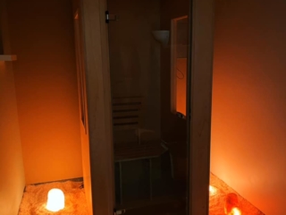 Wooden And Glass Salt Booth On A Himalayan Salt Stone Floor With An Almost Salt-Covered Ground And Three Backlit Salt Stones On Each Side.