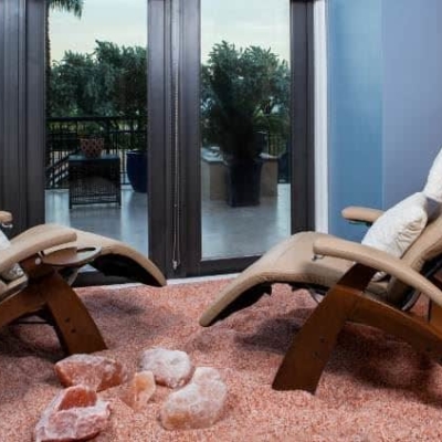 Two lounge chairs on a Himalayan salt-covered floor facing an window looking outdoors at nSpa Delray Beach Marriott - DelRay Beach, Florida.