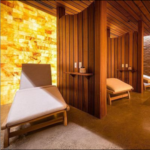 The salt room at the Aqua Spa Float Center & Wellness Boutique in Oswego, New York with two reclining chairs and a Himalayan salt brick wall.