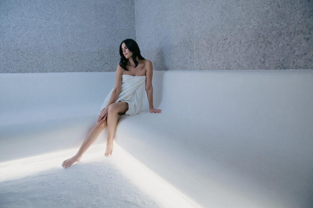 woman in a salt room with white Himalayan salt decor at Auberge Beach Residences in Fort Lauderdale, Florida
