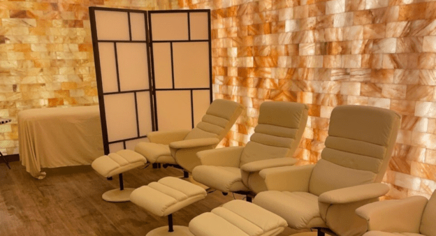 Salt Therapy Room With 3 Chairs, A Massage Table And Himalayan Salt Brick Walls.