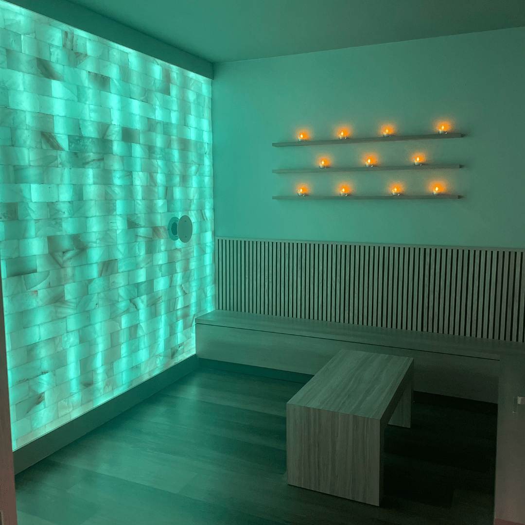 The salt room at The Woodhouse Day Spa in Atlanta, Georgia with benches and a Himalayan salt brick wall.