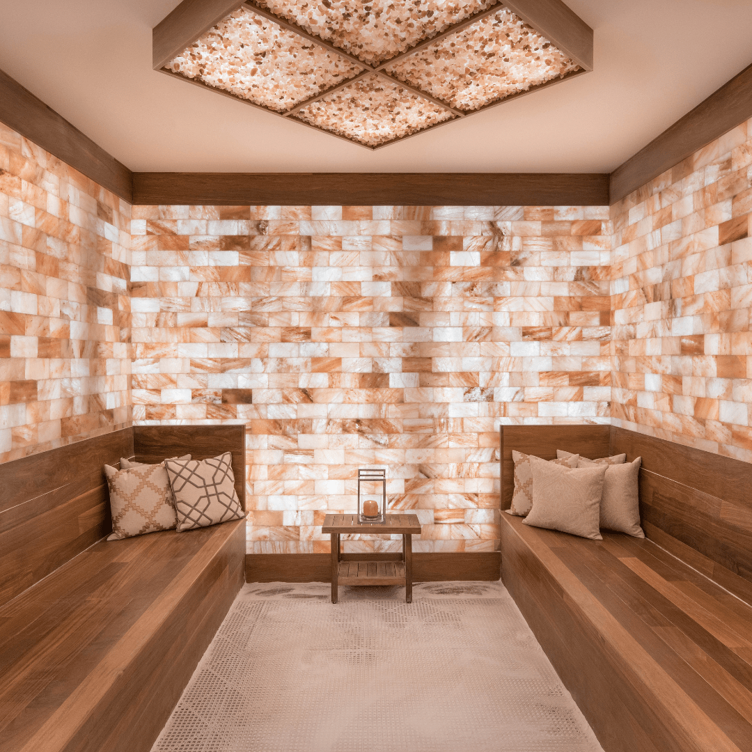 A salt room with 2 long benches, Himalayan salt walls and Himalayan salt panels on the ceiling.